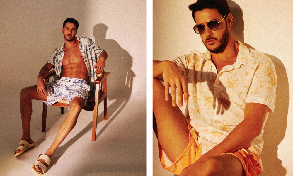 Guia de mala para viagem | Linha Acqua Código Zero. Na imagem é possível observar uma vibe bem veraneia, com luzes que parecem quentes. No lado esquerdo um homem com um conjunto de beach shorts + camisa aberta, com uma estampa de algas azuis da linha Acqua CZ, enquanto do lado direito o homem também veste um conjunto com beach short + camisa estampados de coqueiros. #viagem #verao25 #codigozero #guiademala #viagemfimdeano #lookfinaldeano #praia #acqua #beachshorts 